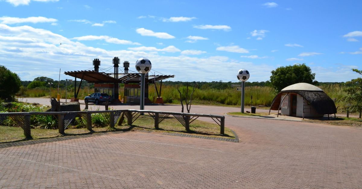 A paved entrance area and security gate structure for Kruger National Park Prices 2026.