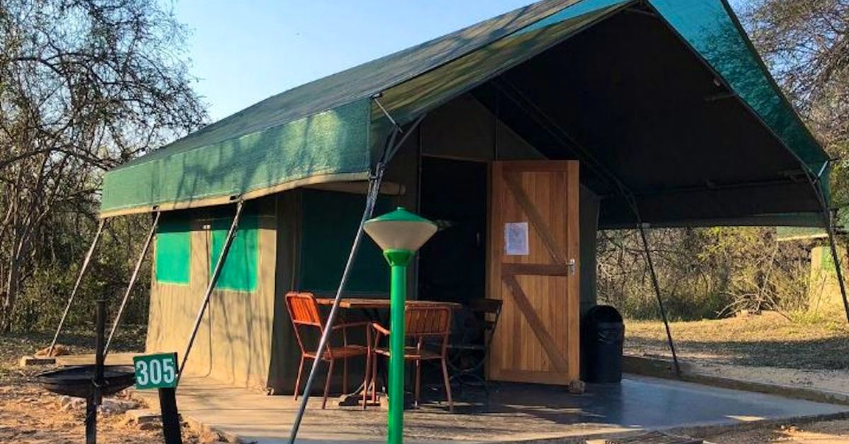 A canvas safari tent accommodation unit with a wooden porch at Skukuza Rest Camp.