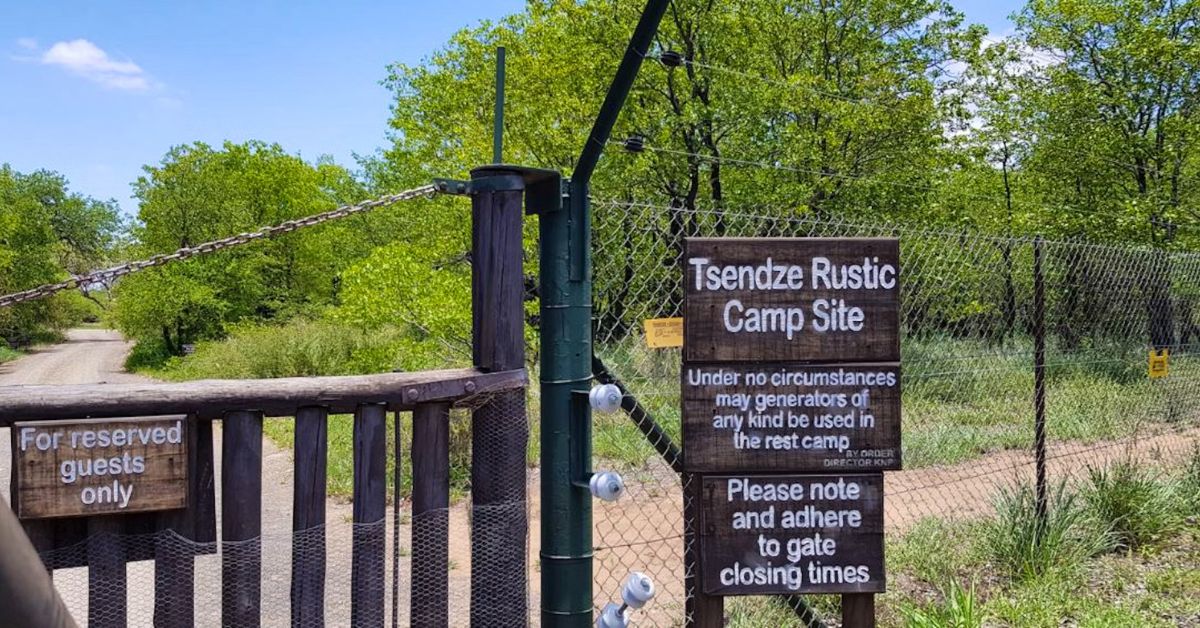 The wooden sign and entrance gate to Tsendze Rustic Camp, welcoming campers to a natural, electricity-free stay in Kruger National Park.